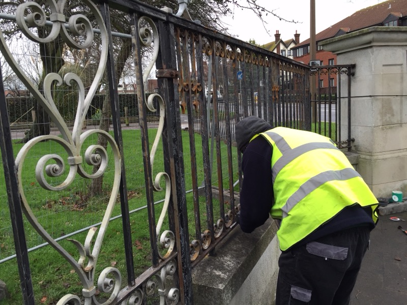 WFE worker repairing ornate iron railings at a public park
