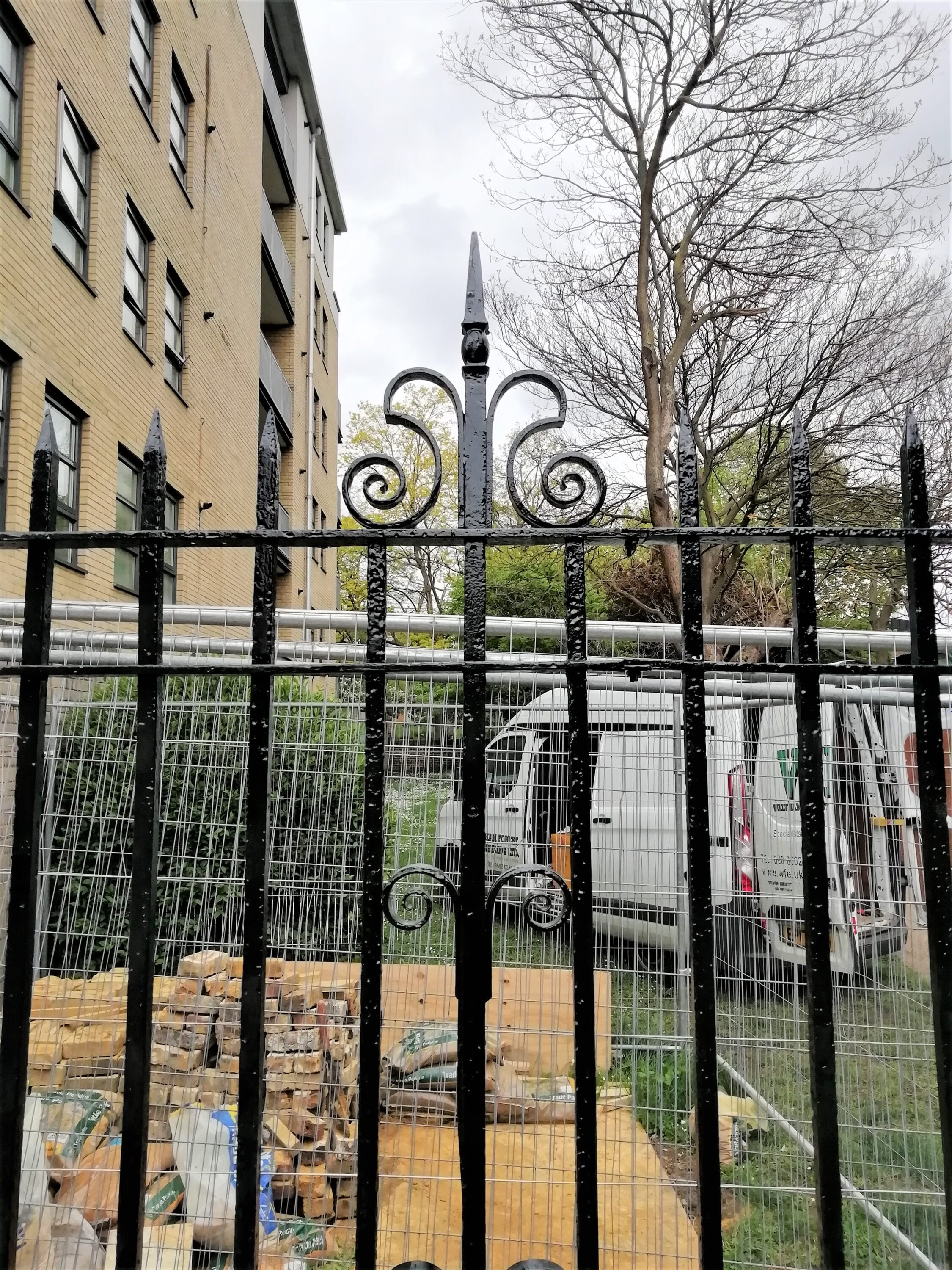 Freshly painted ornate iron gate with scroll finials, Lambeth