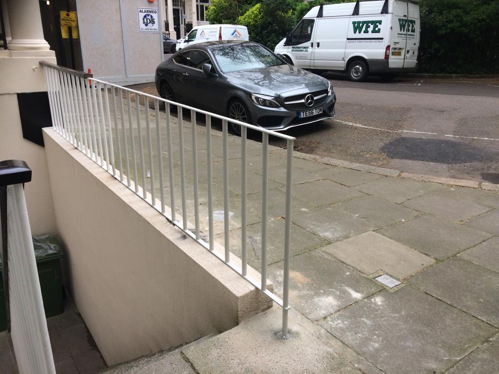Freshly painted white railings on London pavement, Knightsbridge SW7